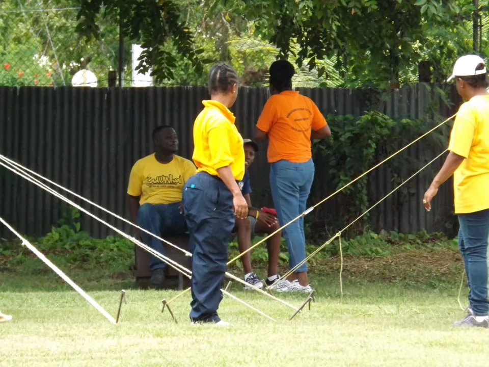 Adults practising rope work during a camping course.